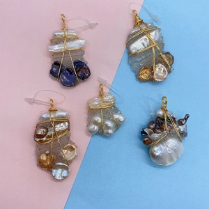 Macro detail of handmade baroque pearl pendants with gold wire wrapping on crystal bases