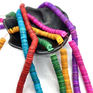 Bunte 7mm Muschel Heishi Perlen für DIY Schmuckherstellung in einer schwarzen Schale