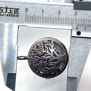 Foto die de diameter van 27mm van de amethist levensboom hanger toont met een schuifmaat