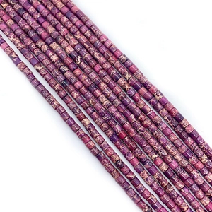 Detailed view of cylindrical purple and beige emperor stone beads for DIY jewelry making