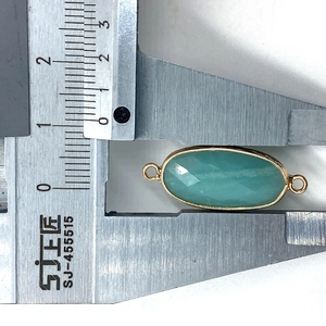 Macro view of faceted oval amazonite connector with gold bezel and measurement