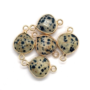 Macro detail of faceted dalmatian jasper teardrop pendants with gold metal frames