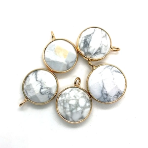 Macro shot of five round white turquoise stone pendants with gold metal frames