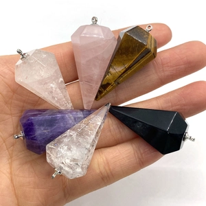 Hand holding natural crystal faceted cone pendants in amethyst quartz and tiger eye