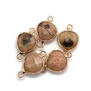 Detail of five faceted sunstone teardrop connectors with gold-plated metal edges for DIY jewelry