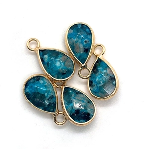 Macro-opname van vier druppelhangers met blauwe steen en gouden rand voor DIY-sieraden