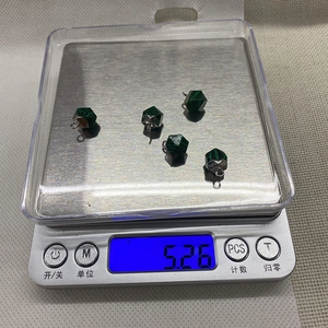Macro shot showing five faceted natural stones on an electronic scale for weight detail