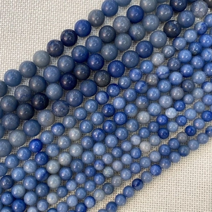Vista detallada de cuentas de piedra natural azul en varios tamaños para joyería DIY
