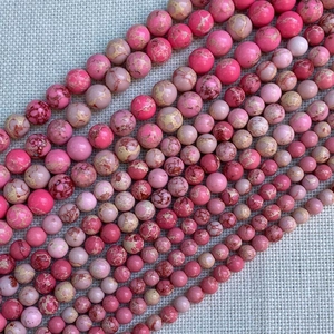 Macro shot of assorted sizes pink imperial jasper round beads for DIY jewelry making