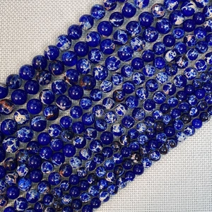 Macro detail of polished sea blue imperial stone round beads with natural marble texture