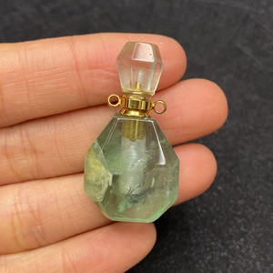 Detail of fluorite gemstone perfume bottle pendant with faceted cut and gold dual loops