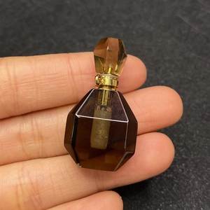 Macro shot of smoky quartz heart perfume bottle pendant with gold metal link hardware