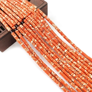Macro detail of 2x4mm cylindrical orange turquoise beads with white marble texture for DIY