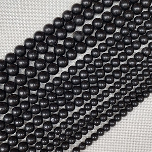 Macro detail of various sizes of black obsidian beads for DIY jewelry making and crafts