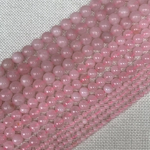 Macro shot of natural rose quartz round beads in various sizes from 4mm to 12mm for DIY