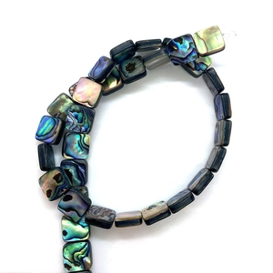 Macro detail of natural square abalone shell beads showing vibrant iridescent textures