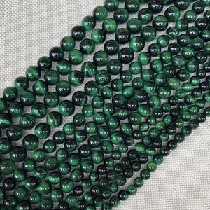 Polished green tiger eye gemstone beads showing natural chatoyancy for DIY jewelry making