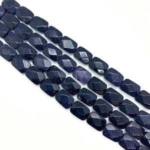 Macro detail of faceted blue goldstone rectangle beads with sparkling starry effect