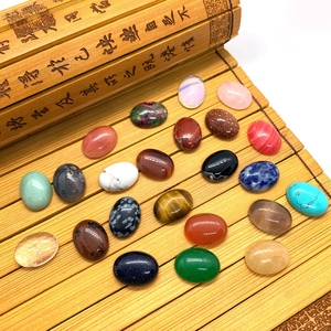 Polished oval tiger eye and natural gemstones arranged on a traditional bamboo mat