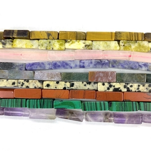Detailed flat lay of rectangular natural gemstone beads including tiger eye and amethyst