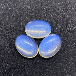 Macro-opname van drie ovale cabochon-edelstenen in melkblauw met glad gepolijst oppervlak