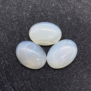 Macro-opname van drie ovale witte chalcedoon cabochons met natuurlijke texturen