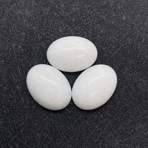 Detail van drie ovale witte chalcedoon edelstenen op een zwarte getextureerde achtergrond
