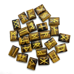 Macro shot of polished tiger eye rune stones with engraved gold ancient symbols
