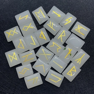 Macro detail of Elder Futhark golden runes engraved on white rectangular divination stones