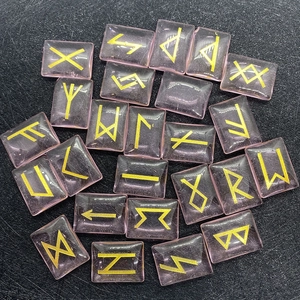 Macro shot of rectangular pink quartz rune stones with gold engraved Norse symbols