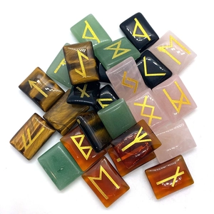 Polished natural gemstone runes including tiger eye and obsidian with gold engraved symbols
