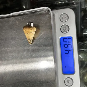 Detailed view of natural stone pendant weighing 4.7g on an electronic scale for DIY jewelry