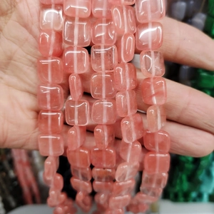 Close-up of polished pink quartz square beads for DIY jewelry making and crafts