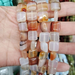 Macro shot of polished square rounded natural agate beads with translucent texture