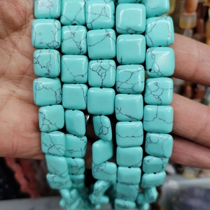Macro detail of square blue turquoise stone beads with natural black matrix for jewelry DIY