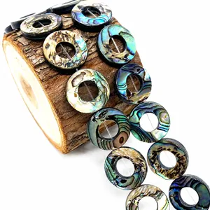 Macro-detail van natuurlijke abalone schelp donut kralen met een levendige regenboogglans