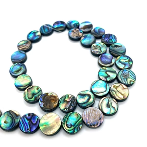 Macro detail of natural abalone shell disc beads with iridescent rainbow luster for DIY jewelry