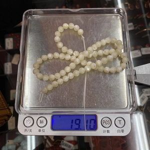 Makroaufnahme von natürlichen weißen Muschelperlen auf einer Waage mit 19,10 Gramm