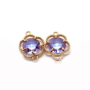 Detailed macro view of purple faceted stone in gold clover flower connectors for jewelry making