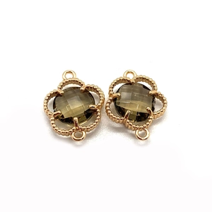 Detailed macro view of clover shape gold plated connectors with faceted brown stones