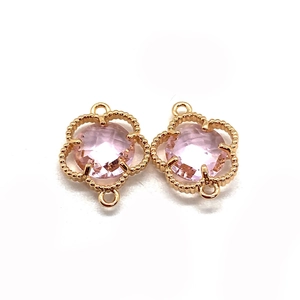 Macro shot of pink faceted stone clover charms with golden beaded edges and dual loops