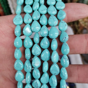 Primer plano de cuentas de piedra turquesa en forma de gota con vetas negras naturales