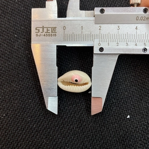 Macro shot showing 19.5mm width of shell bead with evil eye design using a caliper