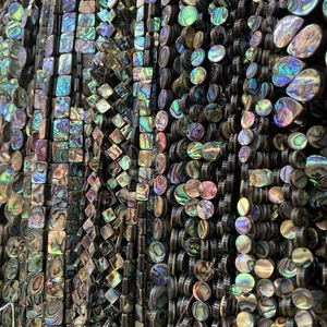 Macro-opname van natuurlijke abalone schelpkralen in diverse vormen met een rijke parelmoerglans