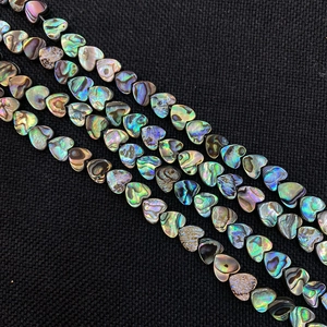Macro-opname van kleurrijke hartvormige abalone schelpkralen voor DIY sieraden maken