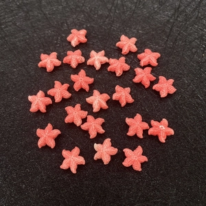 Close-up of pink starfish beads with textured surface and center holes for DIY crafts