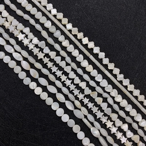 Macro shot of assorted white mother of pearl shell beads in various geometric shapes
