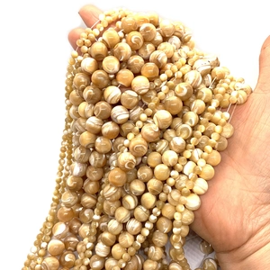 Macro detail of round champagne shell beads with natural pearlescent spiral texture