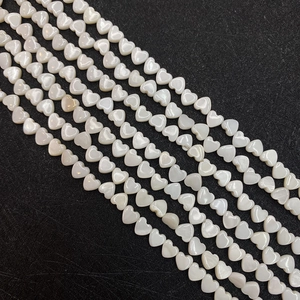Close-up of heart-shaped white mother of pearl loose beads for DIY jewelry making