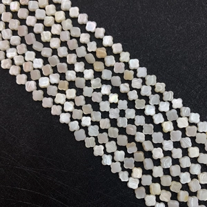 Detailed view of white mother of pearl four-leaf clover beads for DIY jewelry making